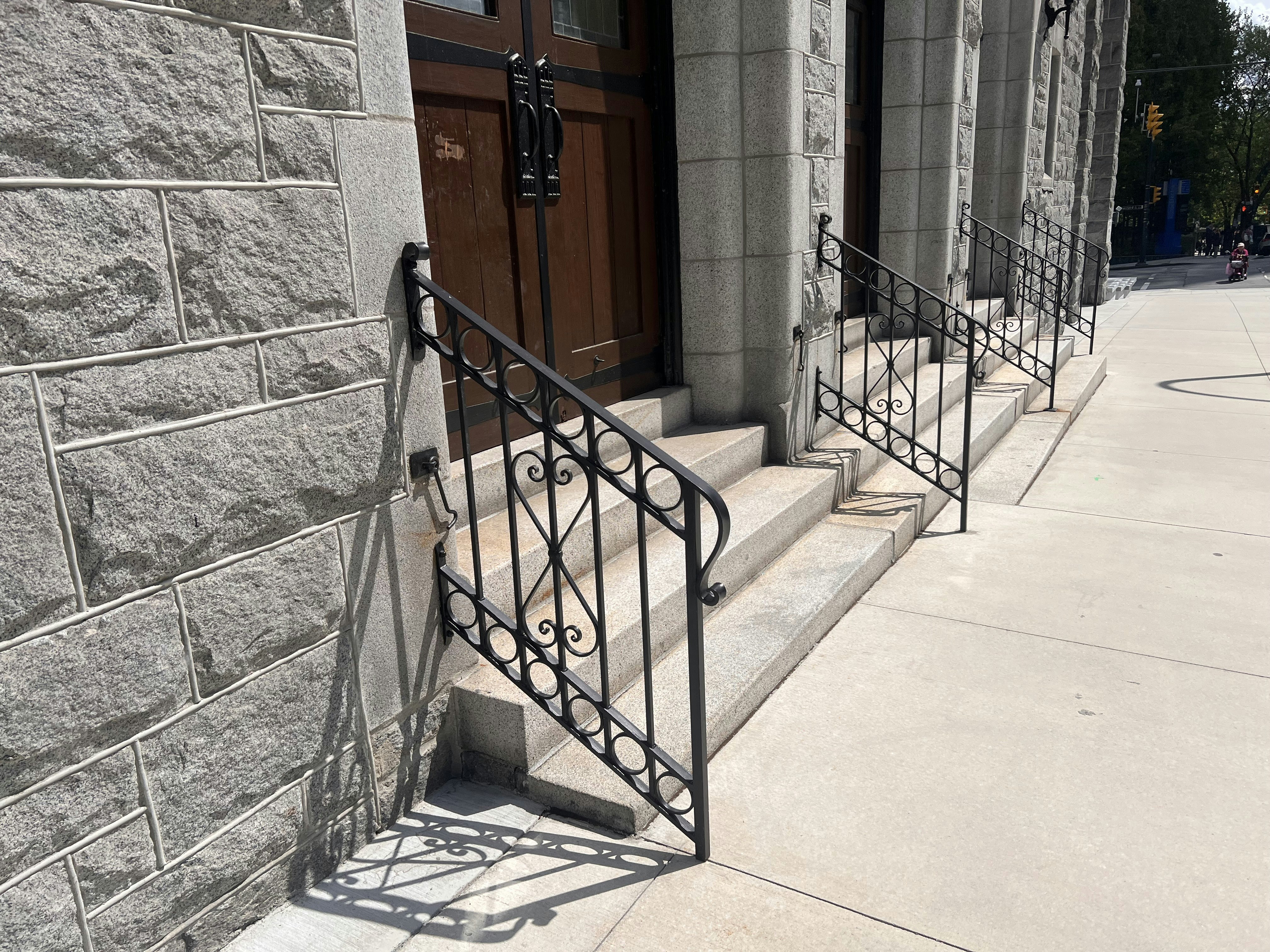 A escada leva a uma porta com corrimão de ferro forjado.