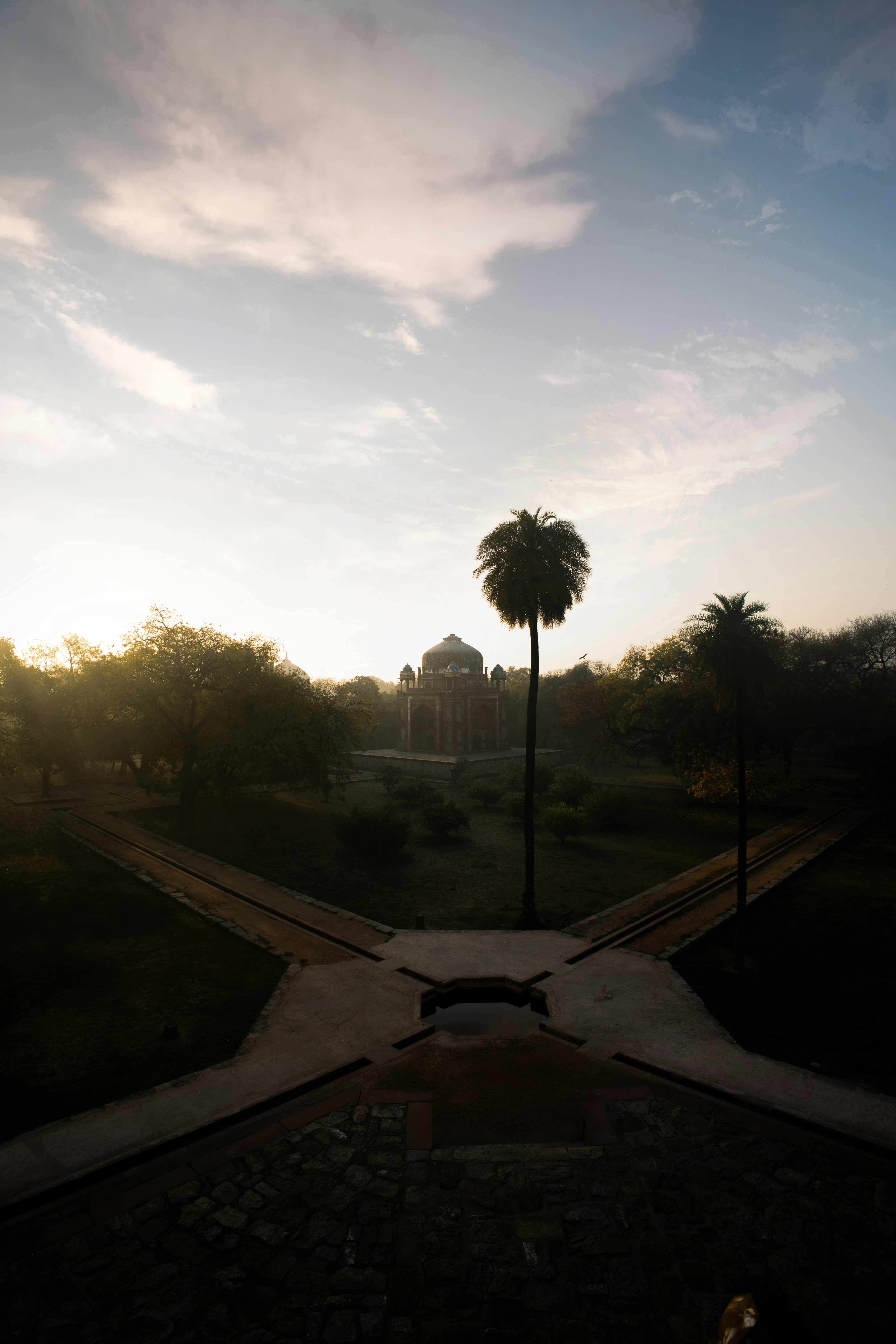 Un parc avec des chemins menant à un bâtiment.