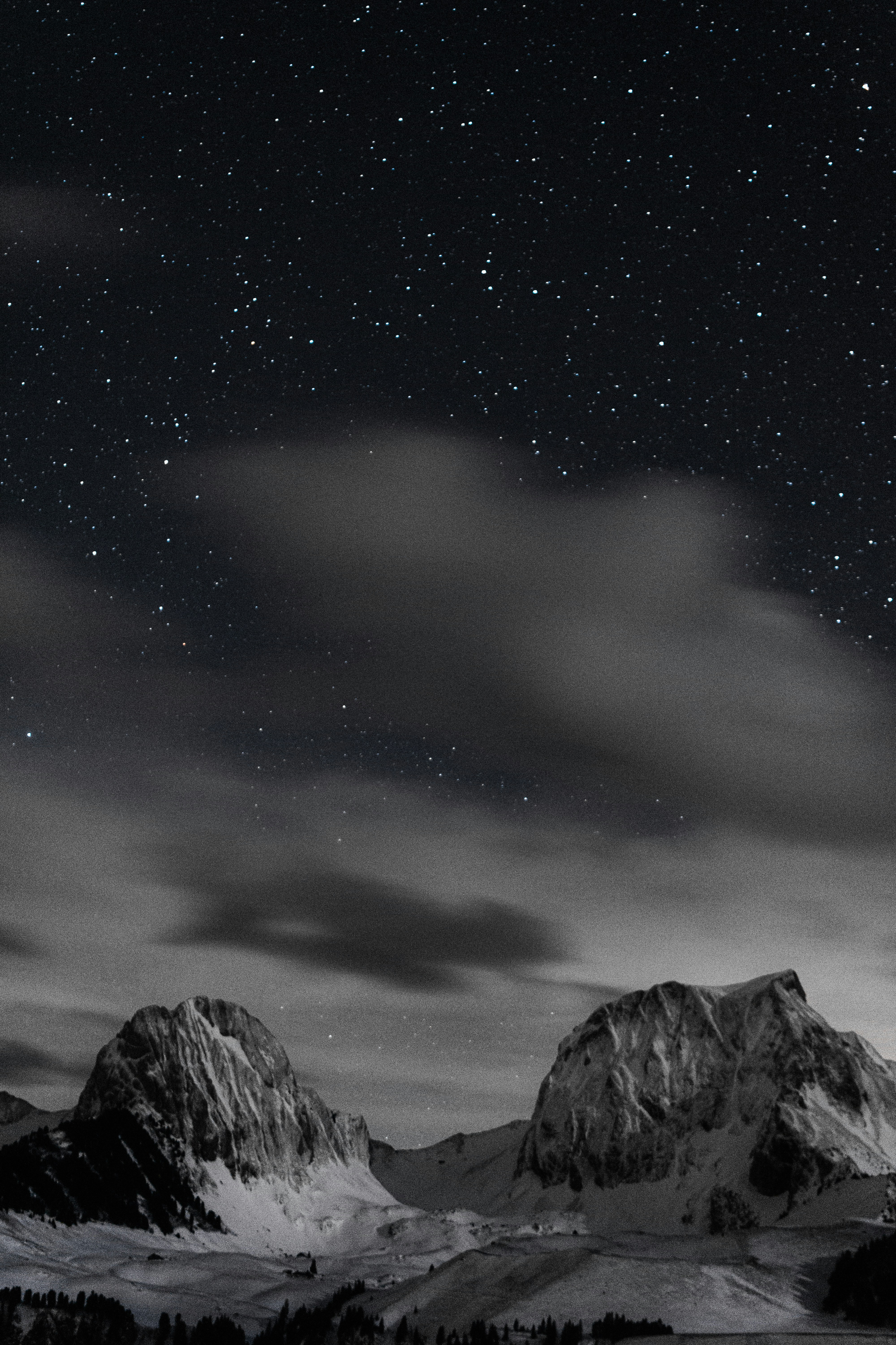 Des montagnes enneigées sous un ciel étoilé.