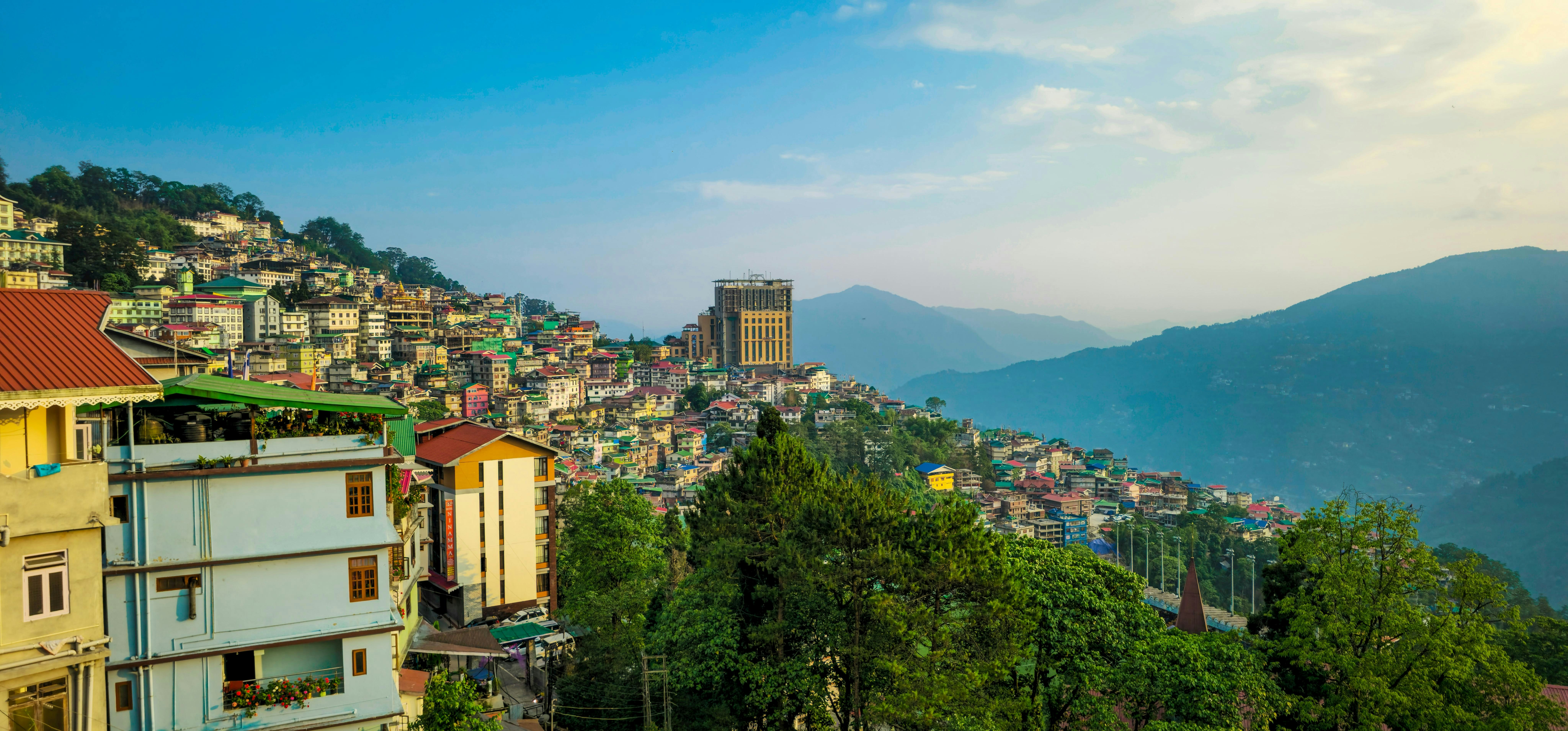Houses cling to a hillside in a mountain valley.