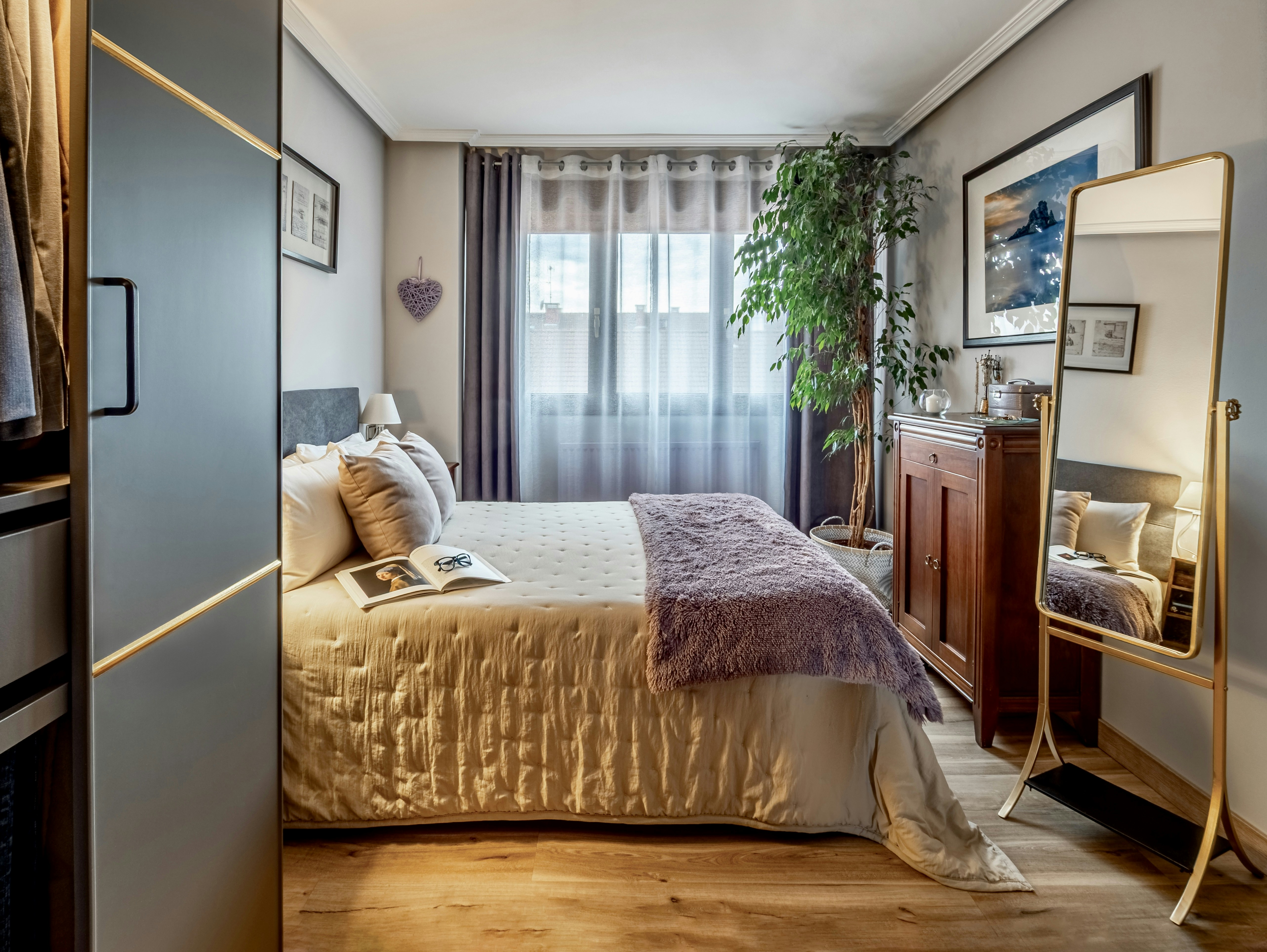 Gemütliches Schlafzimmer mit dekorativem Spiegel und Bett.