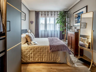 Cozy bedroom with a decorative mirror and bed.