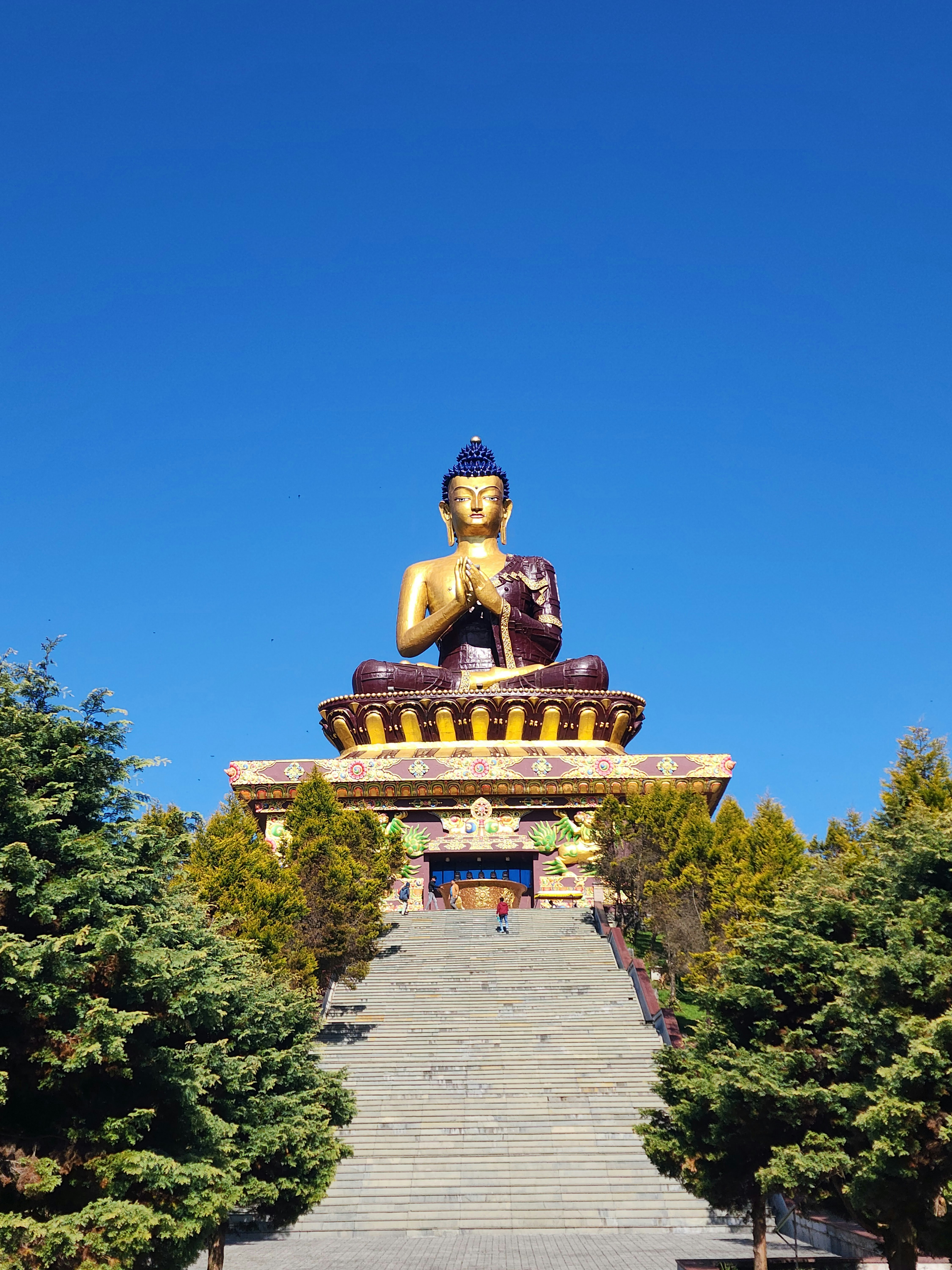 A giant golden buddha statue sits outdoors.