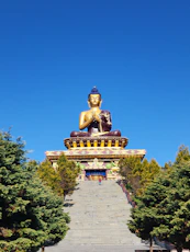 A giant golden buddha statue sits outdoors.