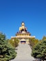 A giant golden buddha statue sits outdoors.