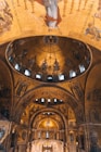 Ornate cathedral interior with golden mosaics.