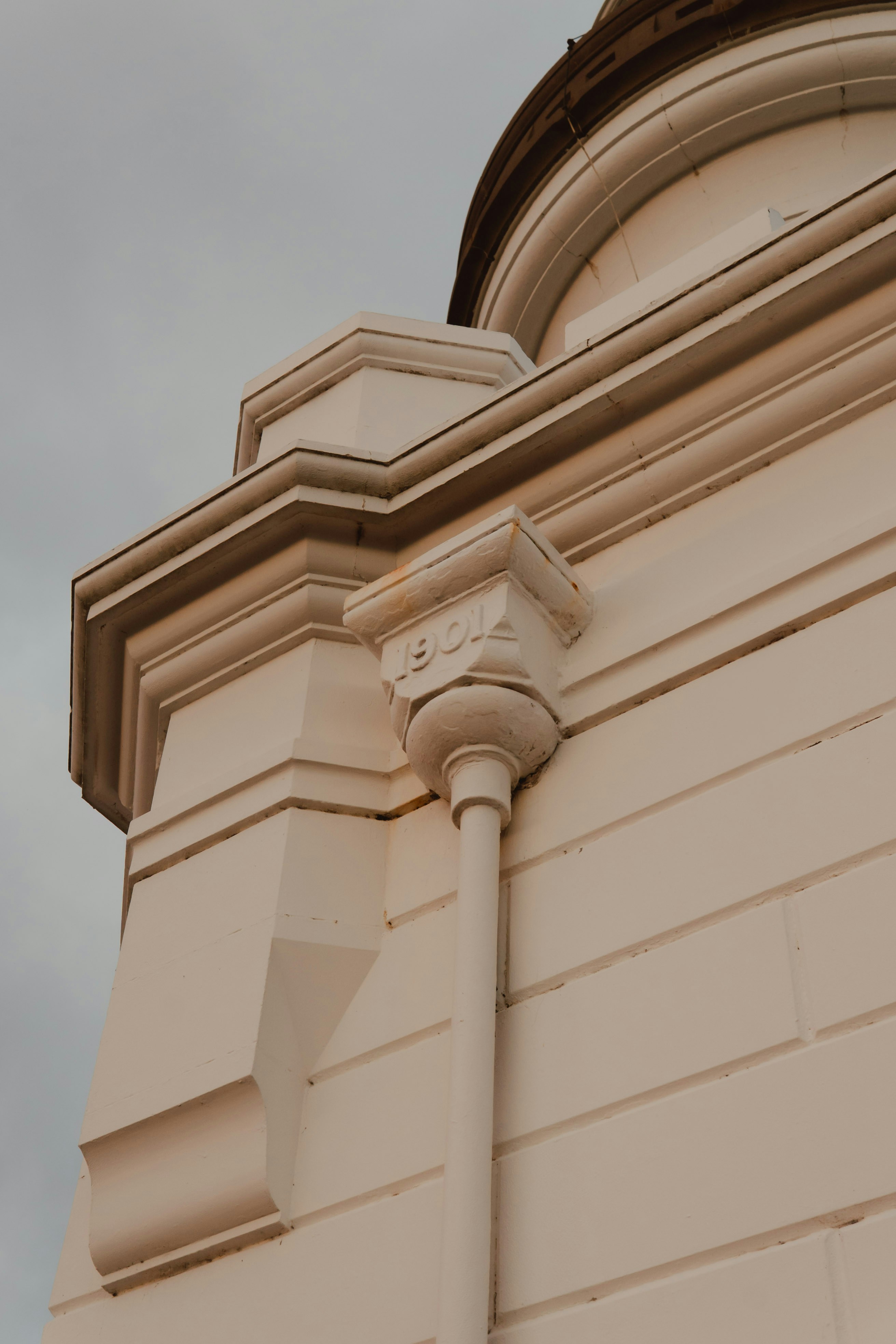 Architectural details of a light-colored building are seen.