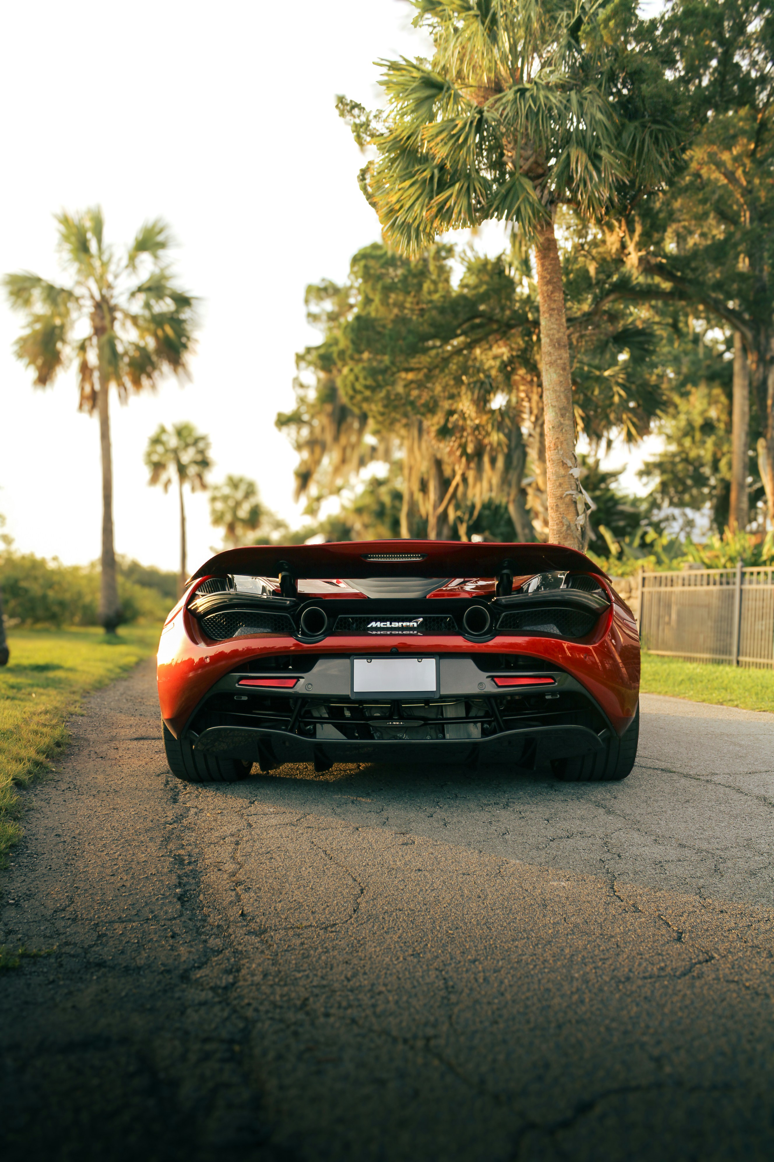 A red mclaren sports car parked on a road.