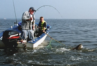 Fishermen catch a fish from a boat in the sea.