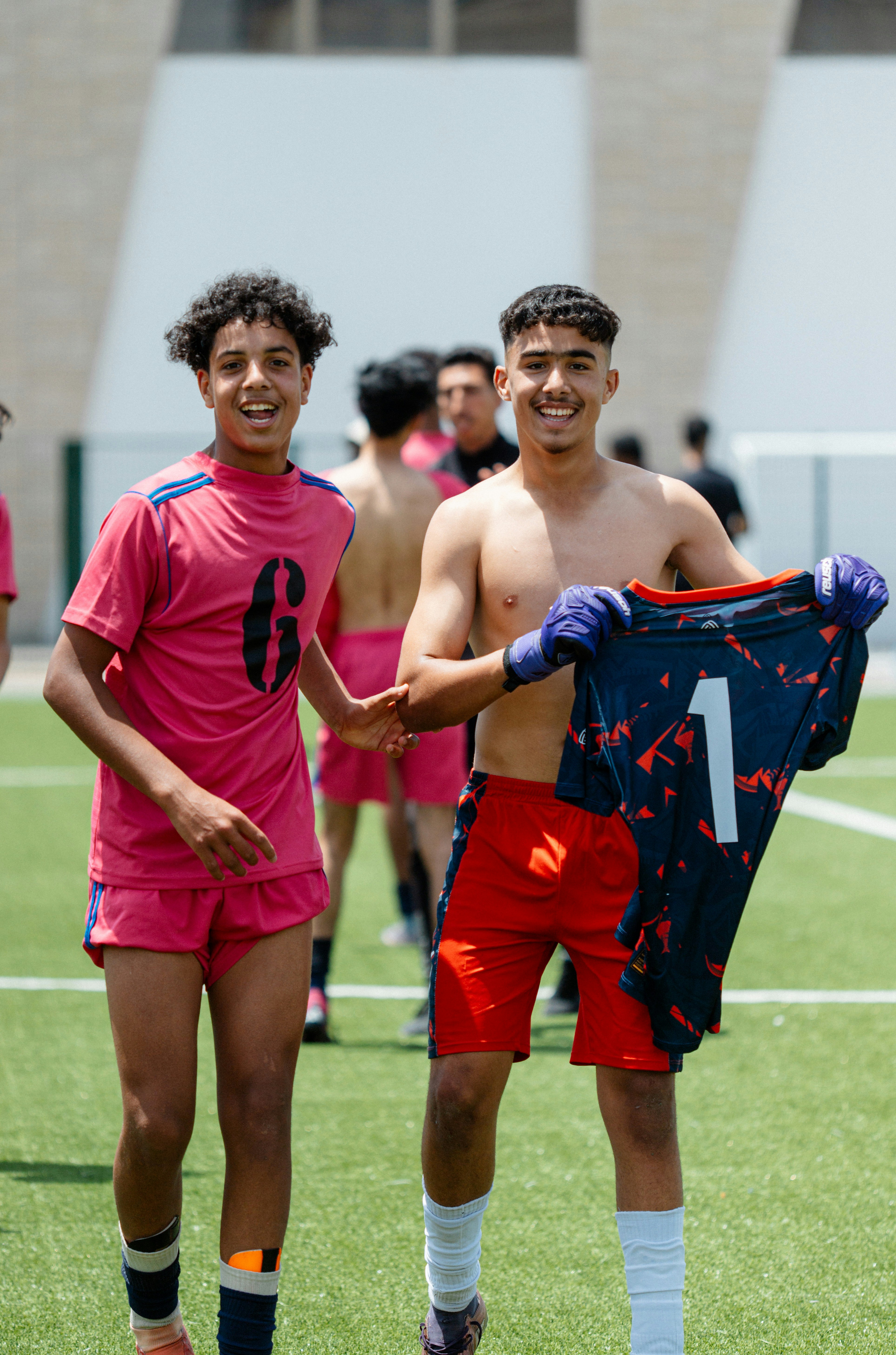 Dua pemain sepak bola yang bahagia merayakan di lapangan.