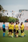 Soccer team huddles with referee before a match.