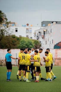 Soccer team huddles with referee before a match.