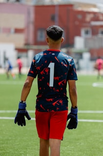 Soccer player wearing number one, facing away.