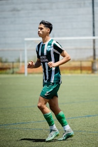 A soccer player runs on the field during practice.