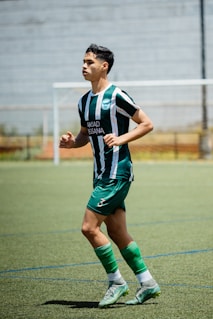 A soccer player runs on the field during practice.