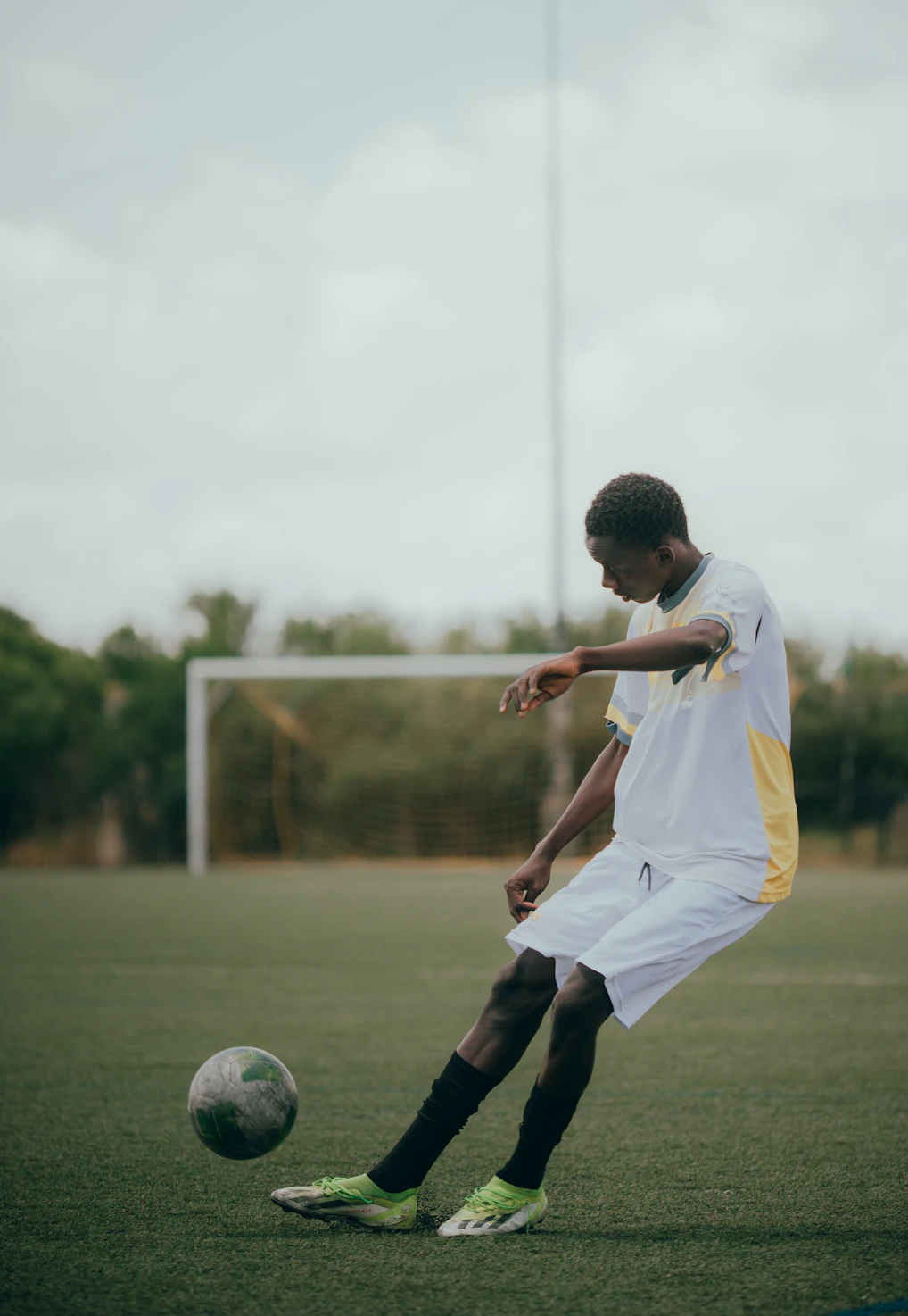 A soccer player kicks the ball on the field.