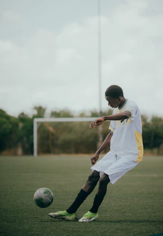 A soccer player kicks the ball on the field.