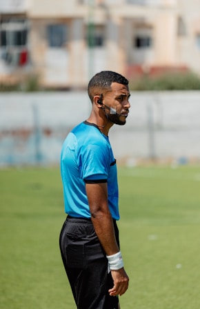 A soccer referee is standing on the field.