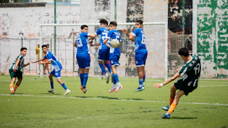 A soccer player kicks the ball in a game.