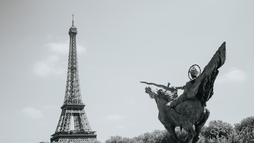 The eiffel tower and a statue in paris.