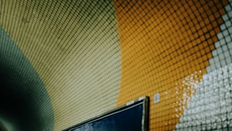 A colorful mosaic tunnel wall is shown.