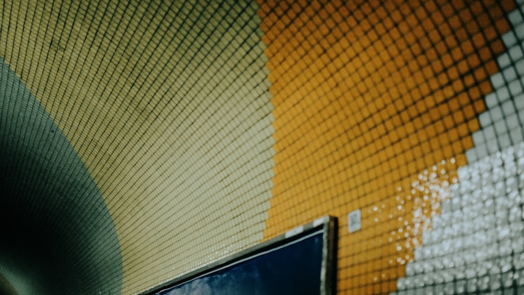 A colorful mosaic tunnel wall is shown.