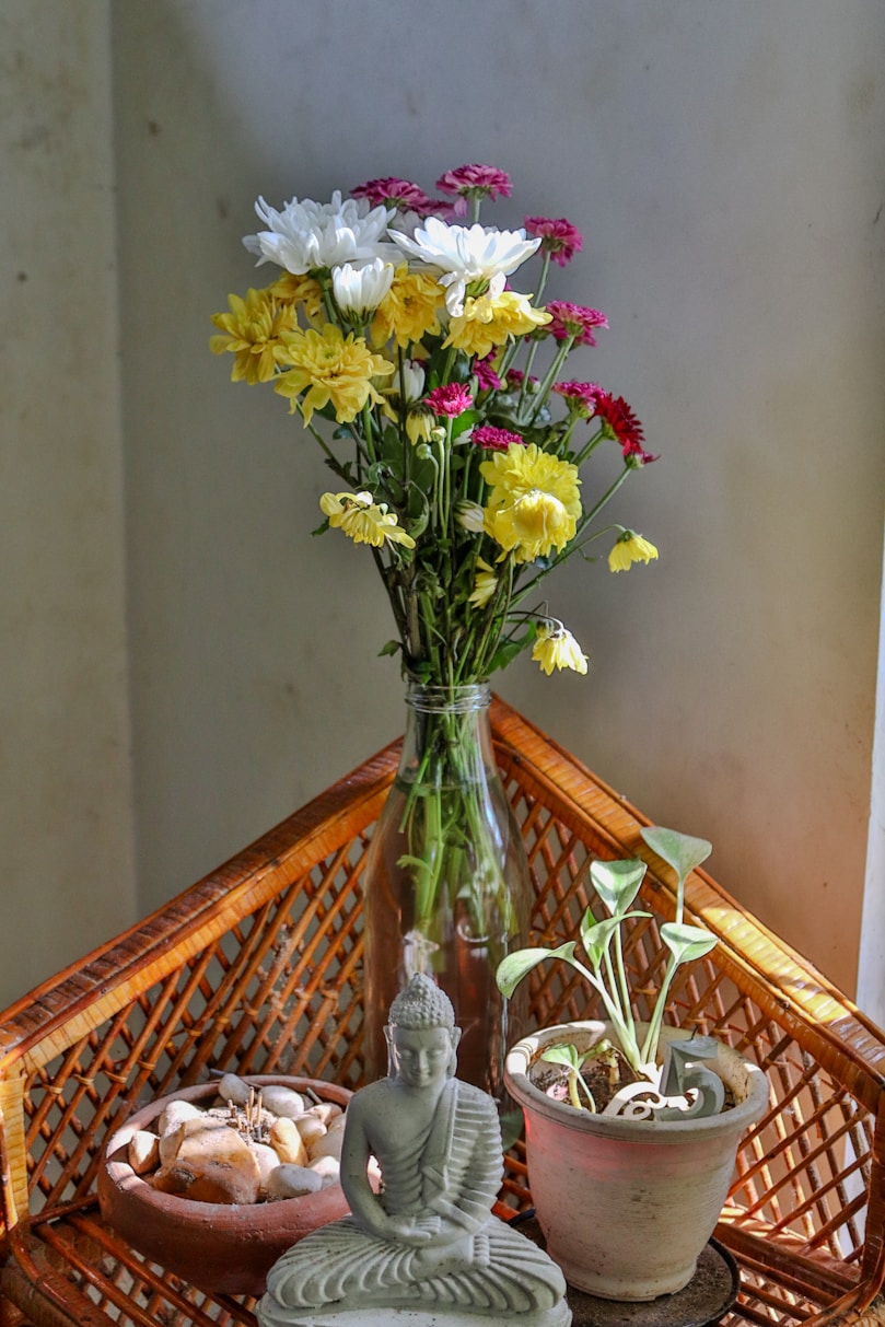 Flowers and buddha decorate a cozy corner.