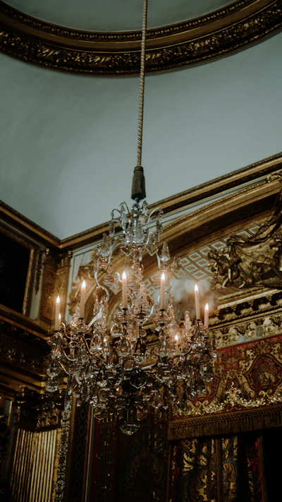 A crystal chandelier hangs in a luxurious room.