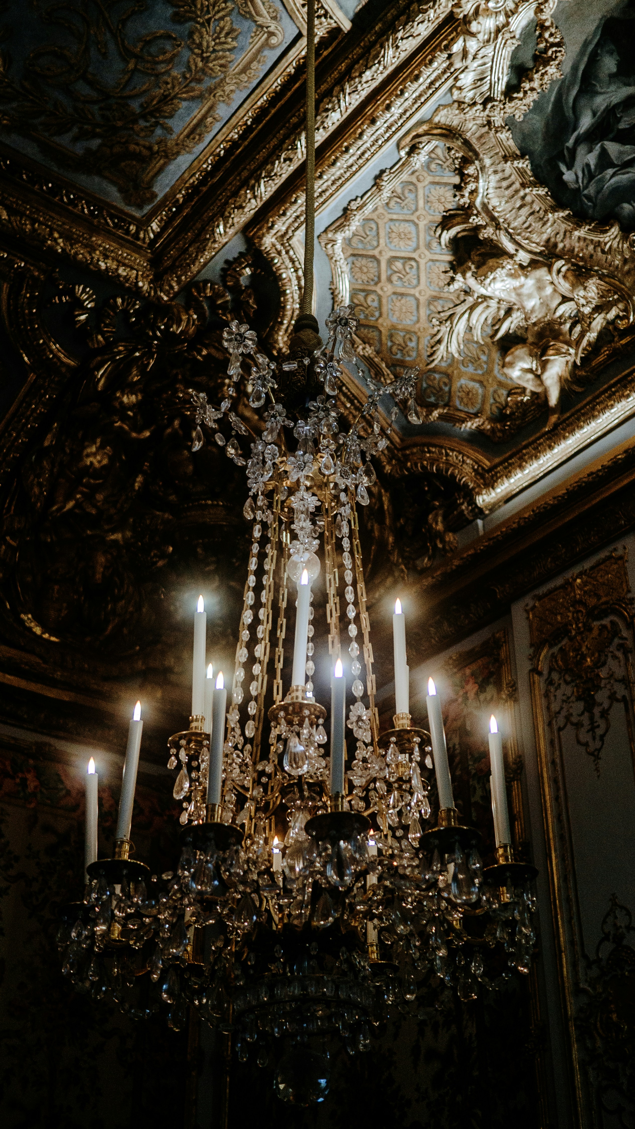 Un gran candelabro cuelga de un techo ornamentado.