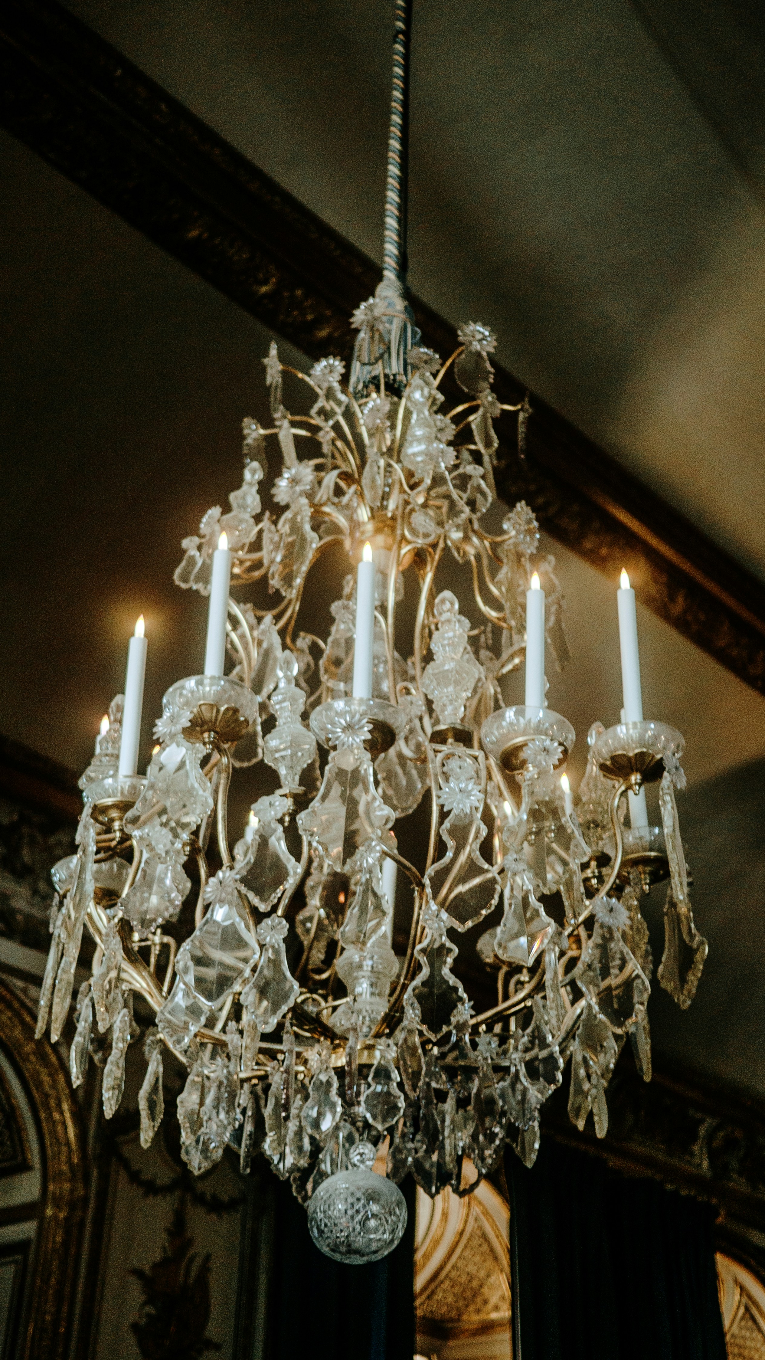 Un candelabro antiguo y brillante cuelga del techo.