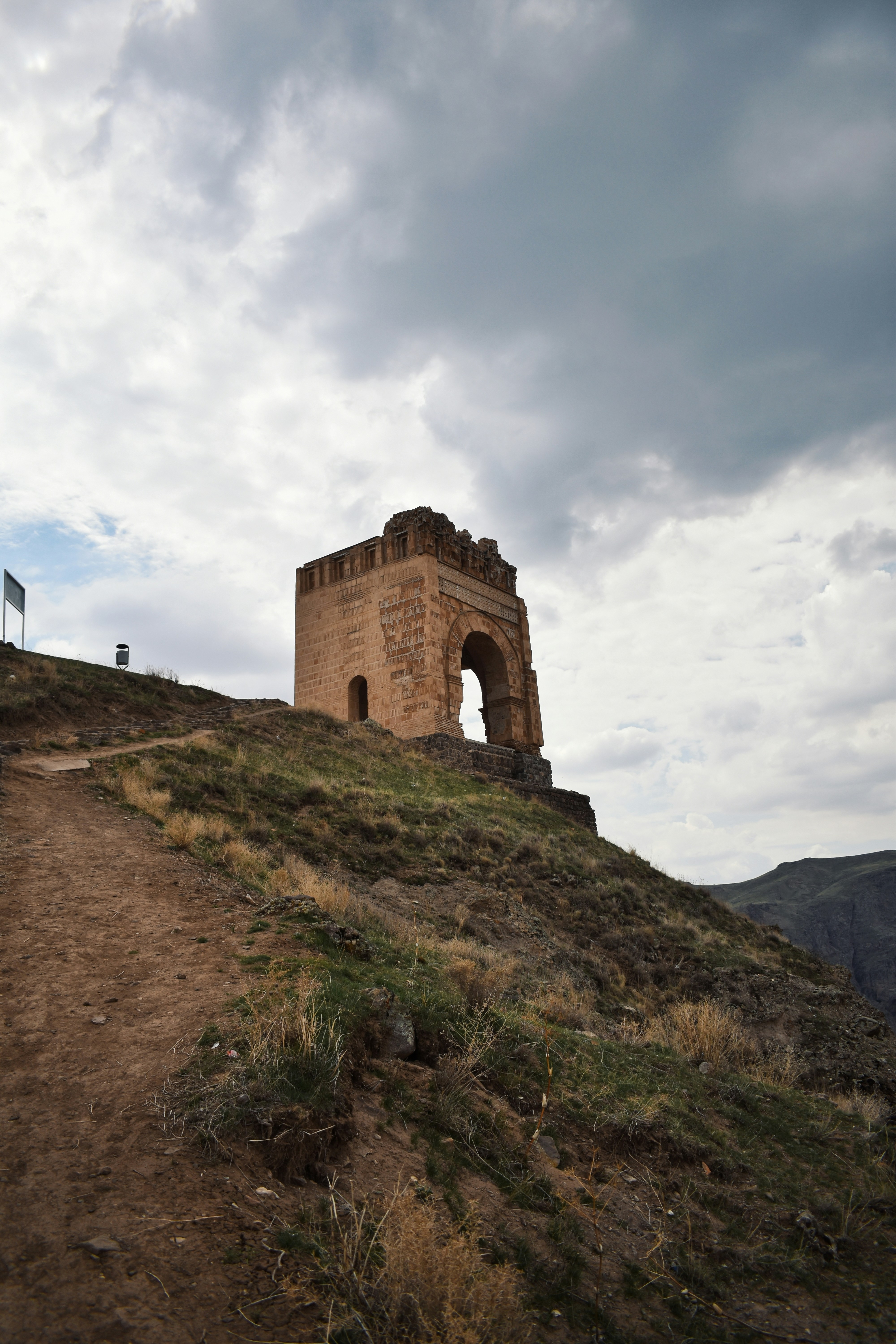 An old stone structure sits atop a hill.