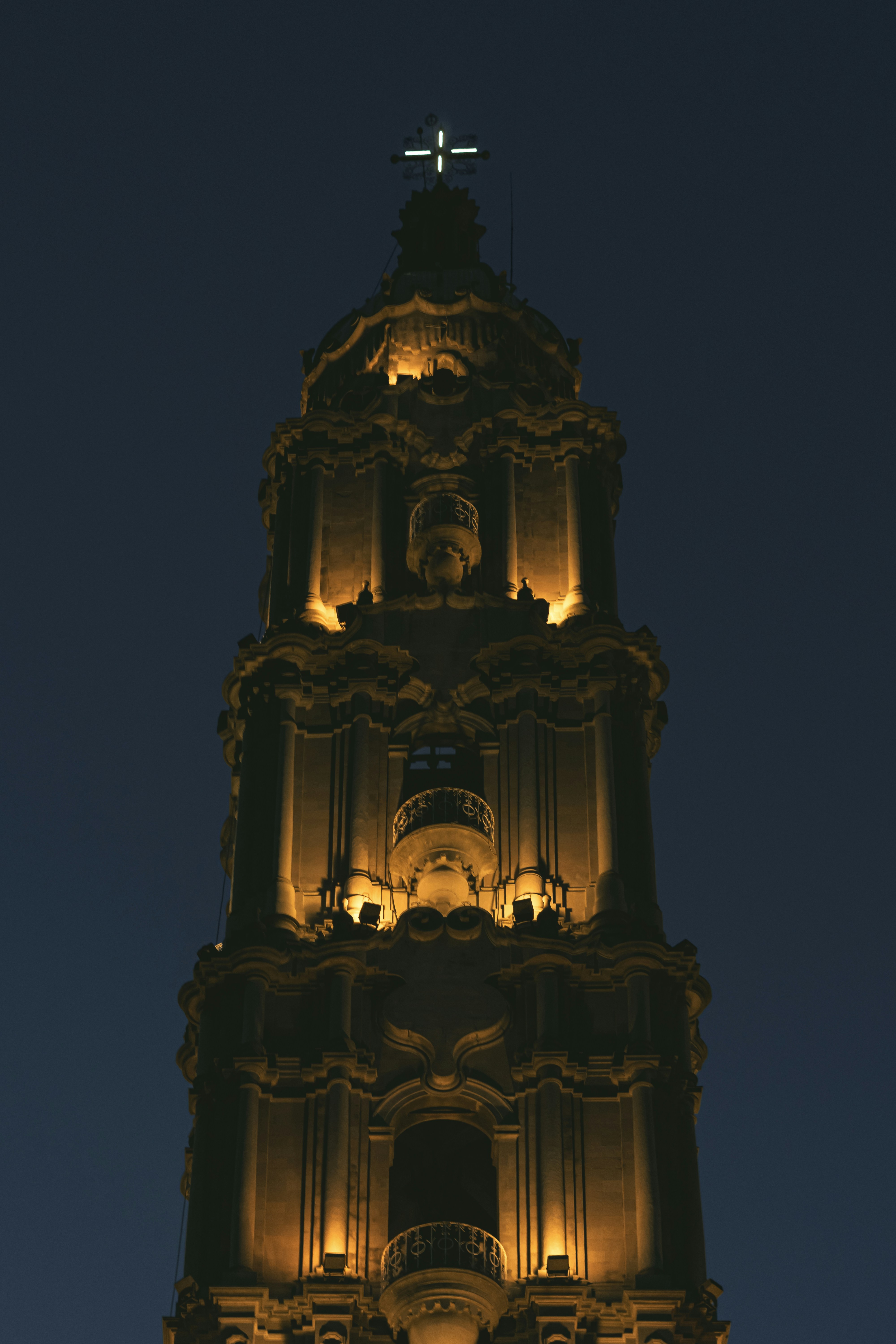 A church tower is lit against the dark sky.