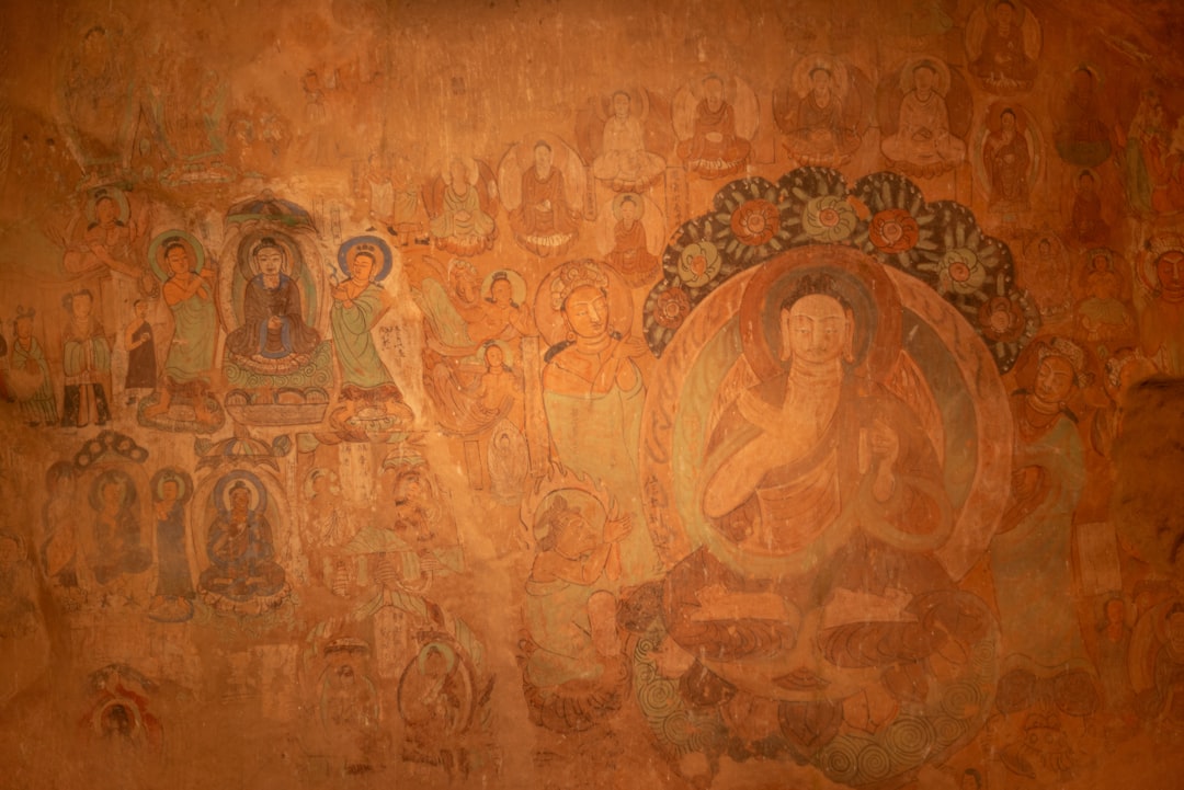 Buddhist mural paintings adorn an ancient wall.,