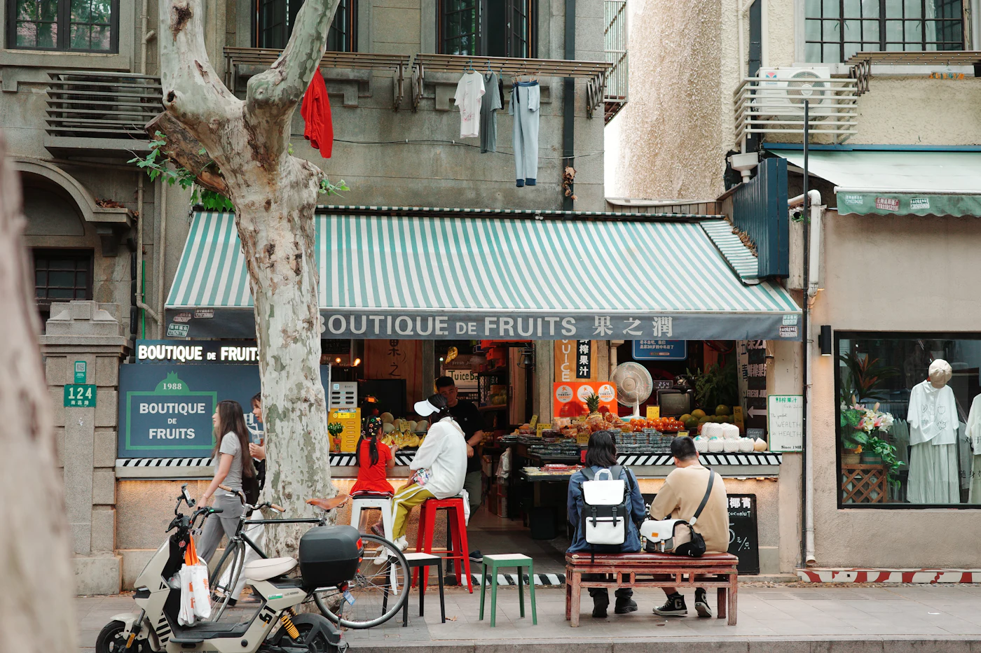 Customers at a fruit shop in China with a scooter parked in front