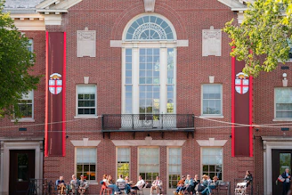 A group of people sits in front of a building
