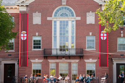 A group of people sits in front of a building