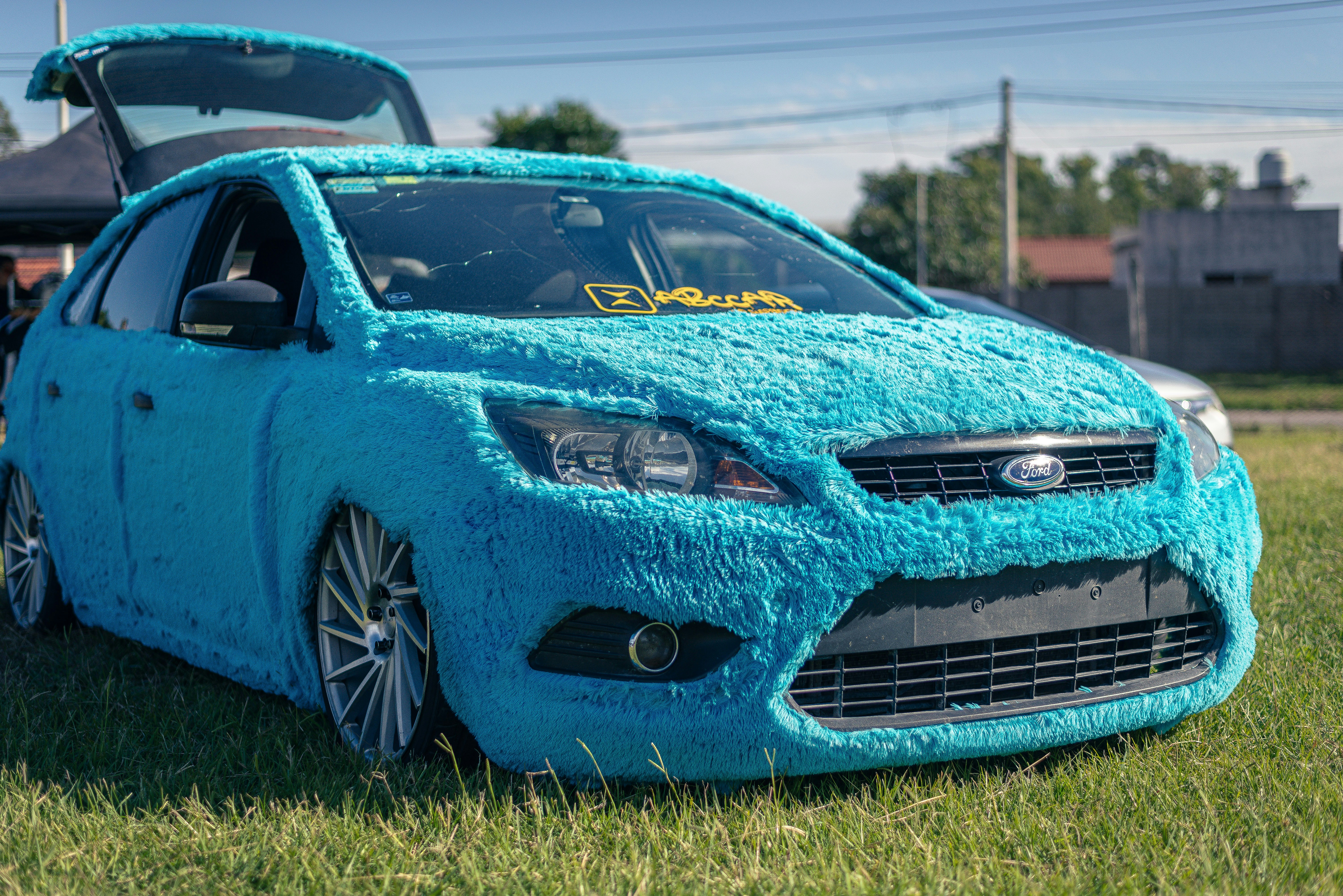 A blue car is covered in fuzzy material.
