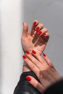 Red nails beautifully displayed on a hand.