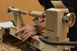 A woodworker uses a lathe to shape wood.