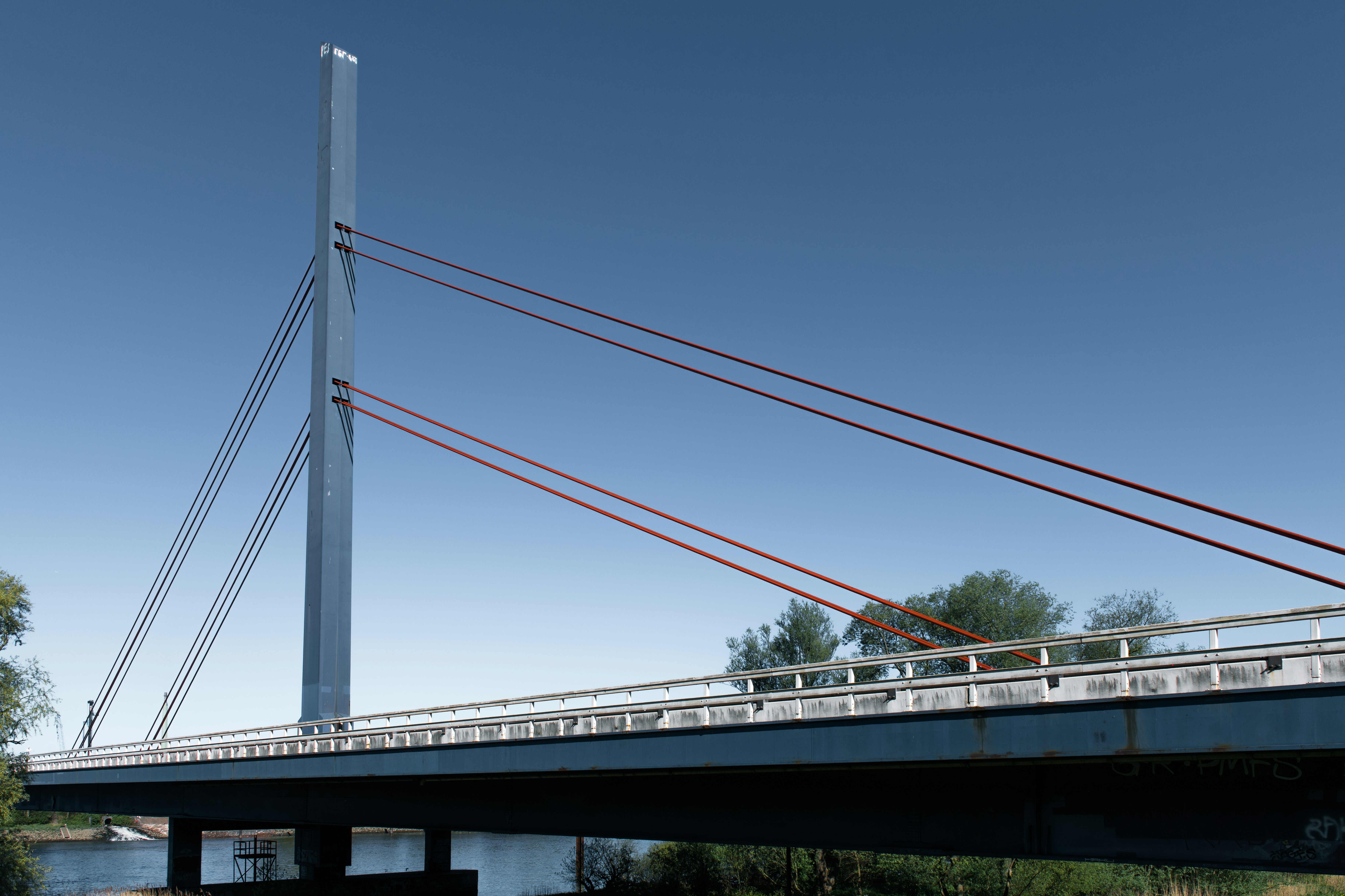 A cable-stayed bridge towers against a clear blue sky.