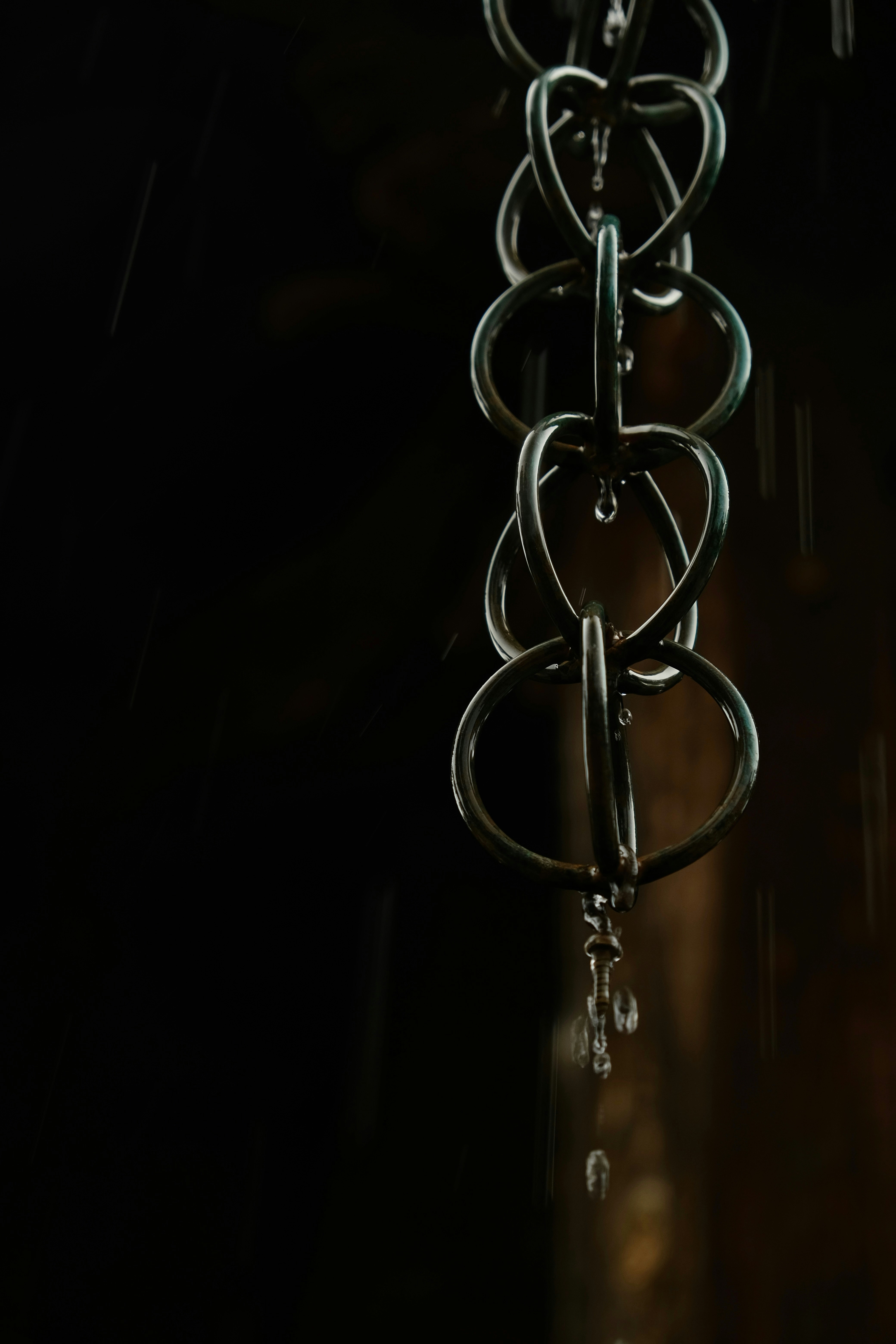 Raindrops cascade down a decorative chain.