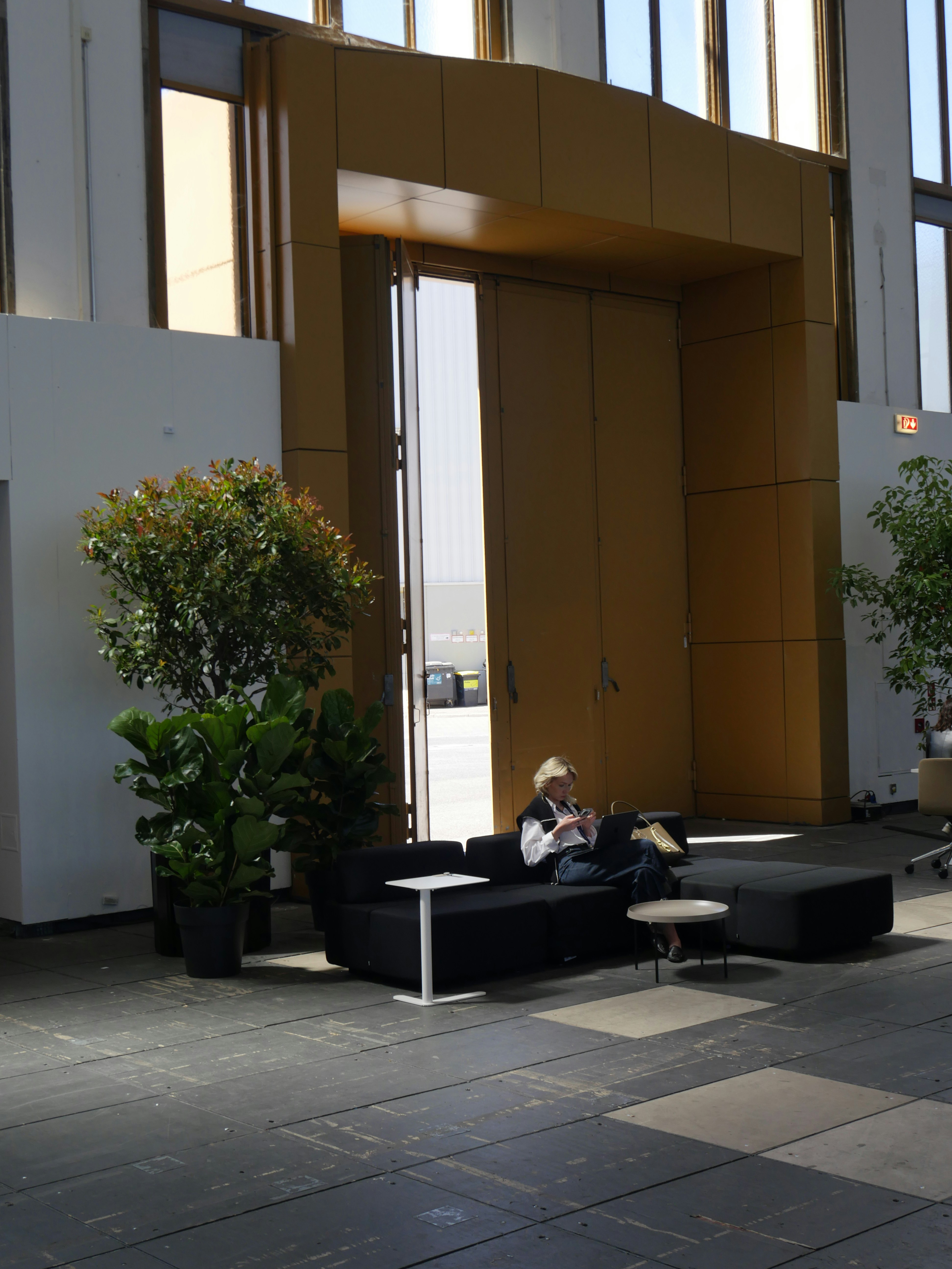 Woman relaxes on a couch near a large doorway.