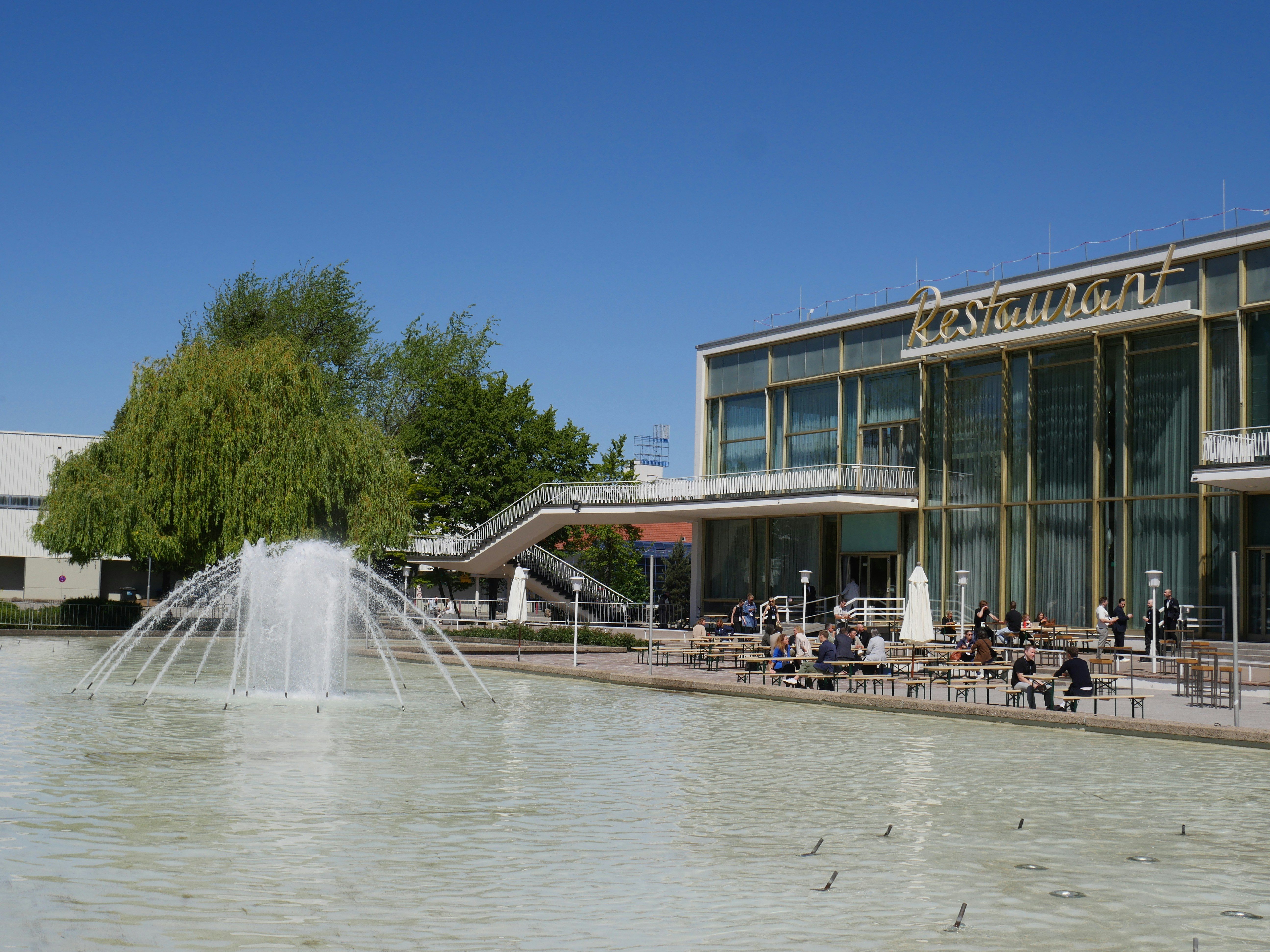 A fountain and building are seen outdoors.