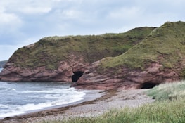 Caves are carved into a coastal cliff.