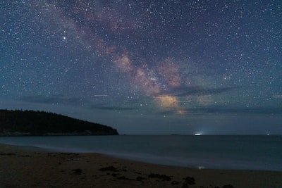 The milky way galaxy shimmers above a serene beach.