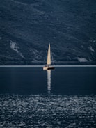 A sailboat glides across the still water.