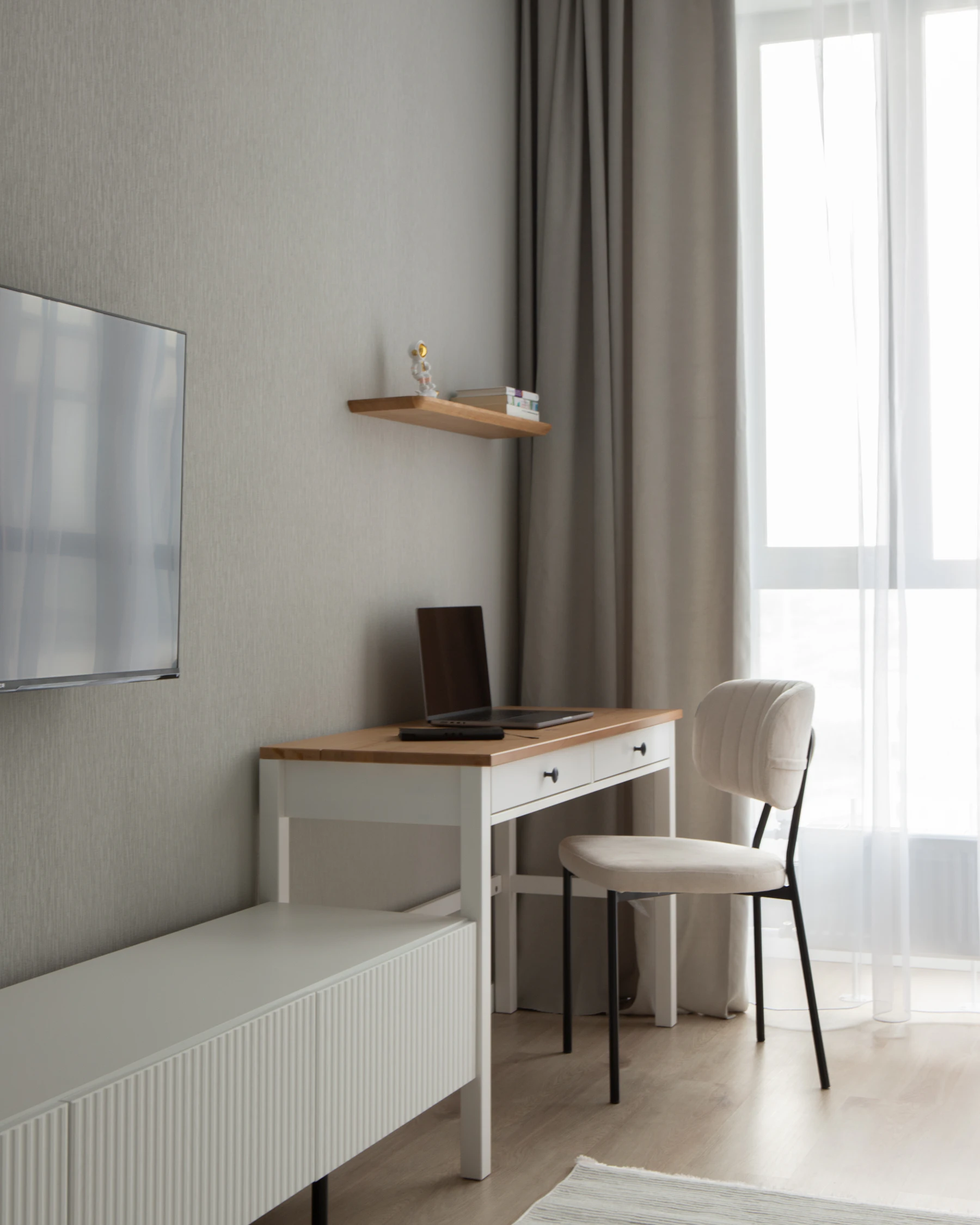 Minimal modern workspace with a desk, chair, laptop, lamp, and warm natural light