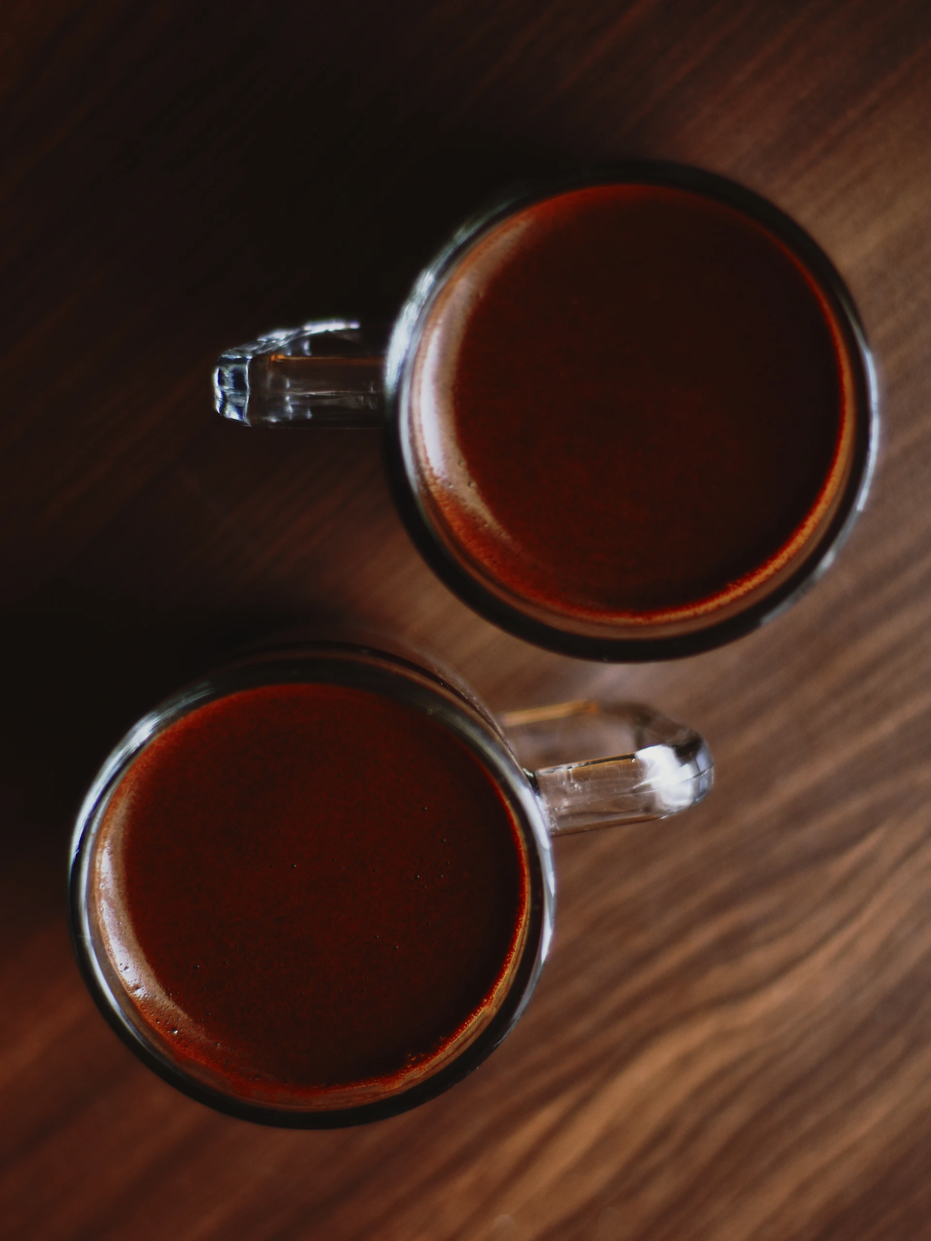 Two mugs of hot chocolate on a table.