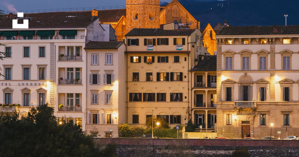 Splashed Buildings Buildings are lit up near the water at dusk. photo – Free City Image on ...