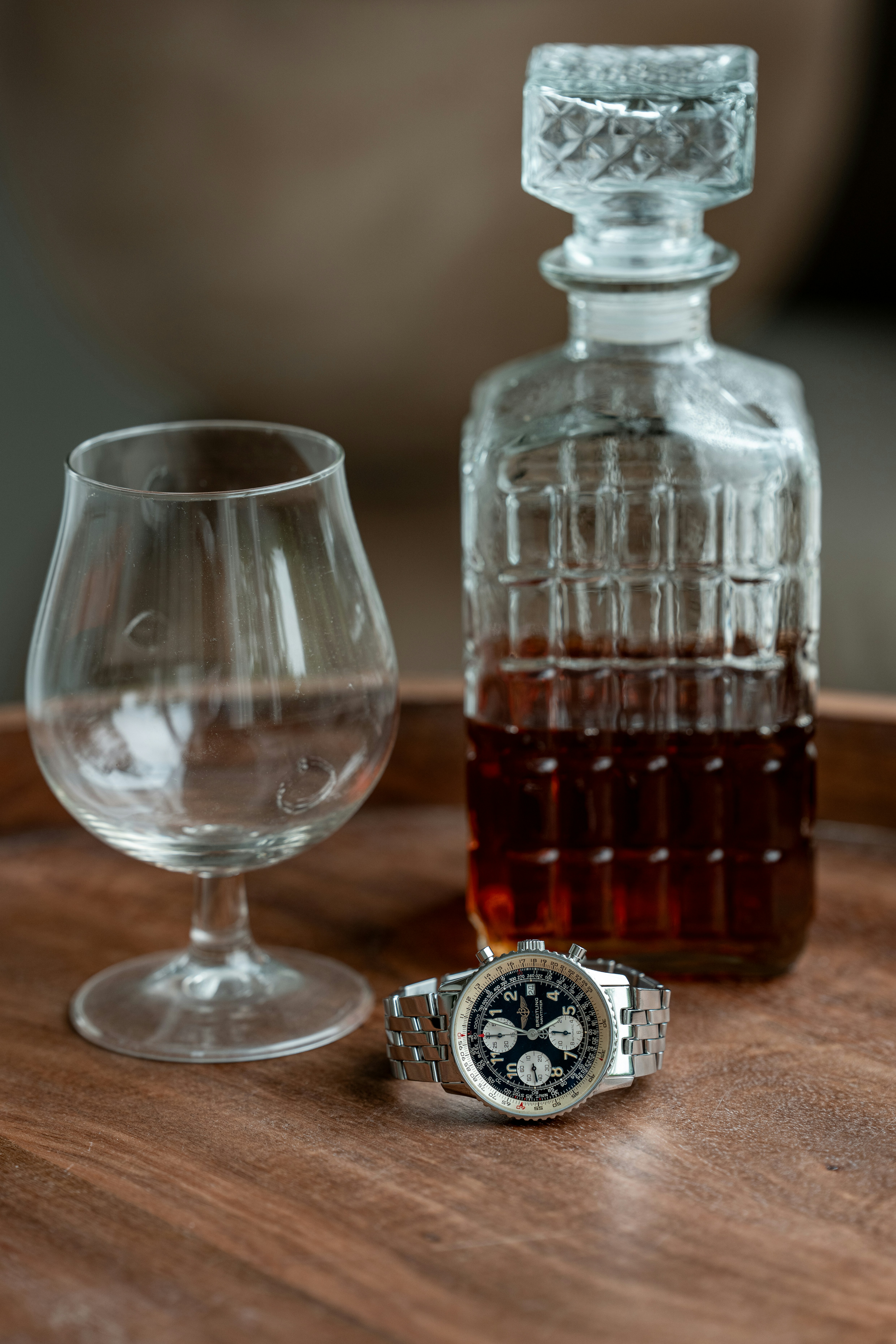 Whiskey, a watch, and an empty glass.